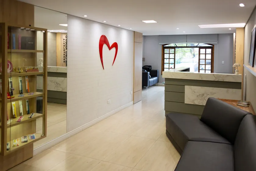 Sala de espera com o símbolo da clínica na parede